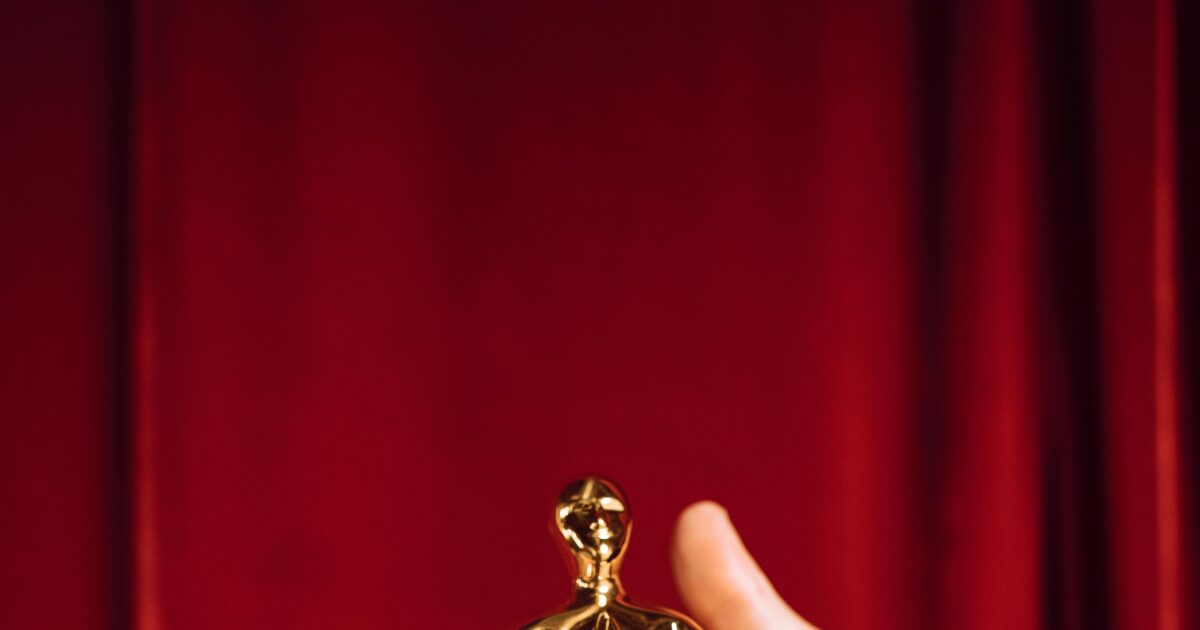 Hollywood award statue on red curtain background