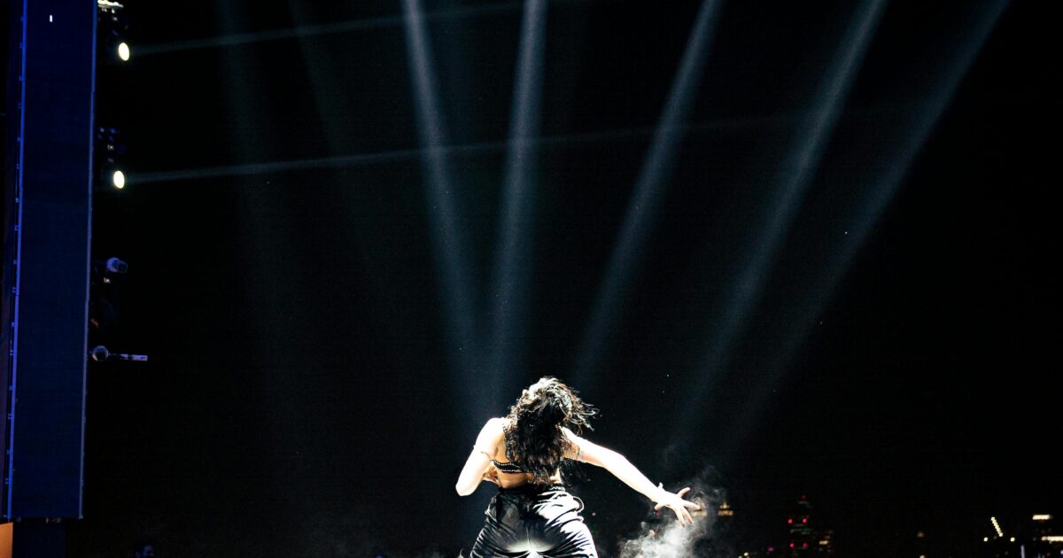 Female pop star performing on stage under bright lights representing Britney Spears concert performance