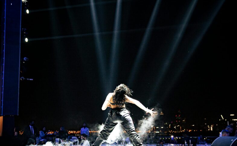 Female pop star performing on stage under bright lights representing Britney Spears concert performance